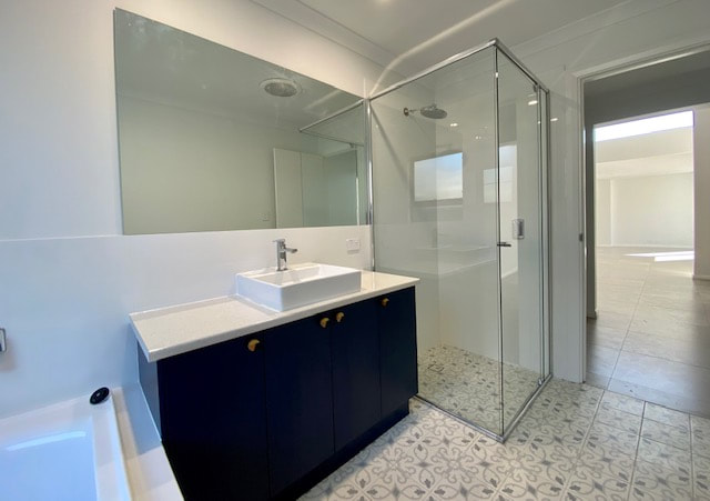 Bathroom Main navy blue cabinets Distinct Renovations 