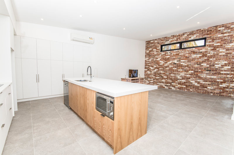 Open plan kitchen and feature brick wall